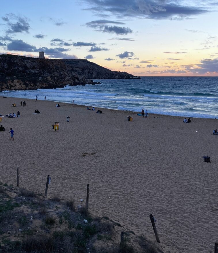 Golden Bay at sunset with warm light over the cliffs and sandy beach.