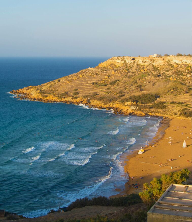 Ramla Bay with its red sand and green hills in the background.