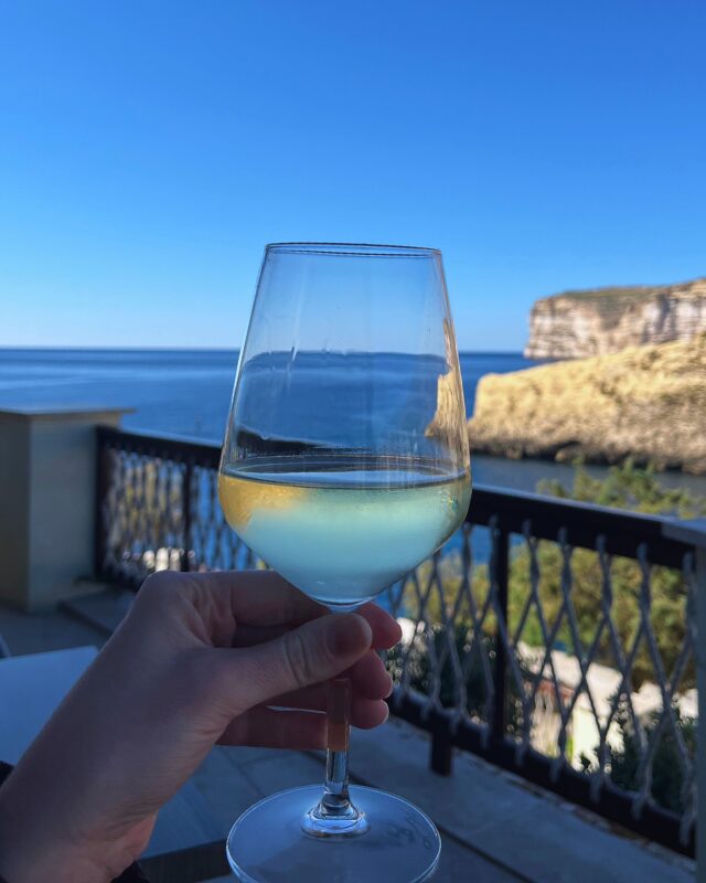 Glass of wine on the terrace overlooking Xlendi Bay at Terrazzo Restaurant, Gozo.